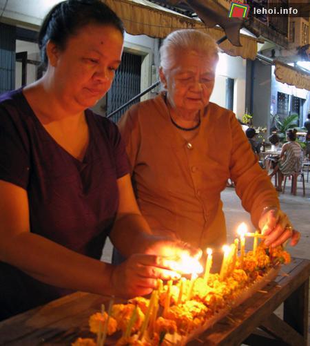 Bà Chaleun Vetthafong cùng con gái thắp nến đêm sau buổi sáng lên chùa:
