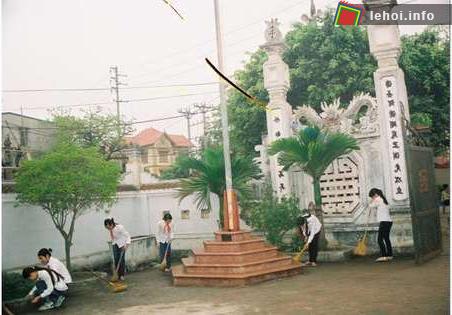 Các em học sinh đang quét dọn sân đình