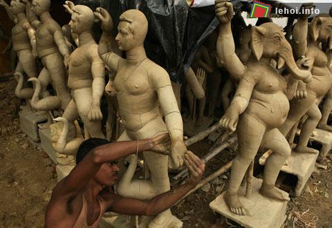 Một nghệ sĩ đang chỉnh lại những tượng thần Hindu trước khi festival Durga Puja diễn ra ở tại Allahabad , Ấn Độ.