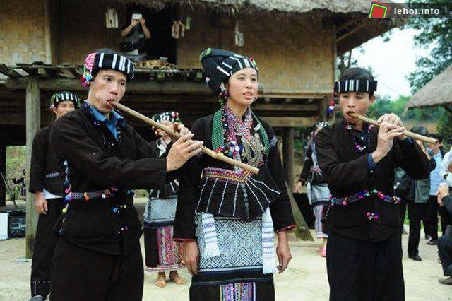Các chàng trai thổi sáo cho các cô gái hát trong lễ hội