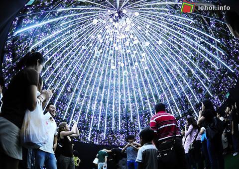 Người dân thích thú chụp ảnh kỷ niệm dưới một chùm ánh sáng đèn lồng.