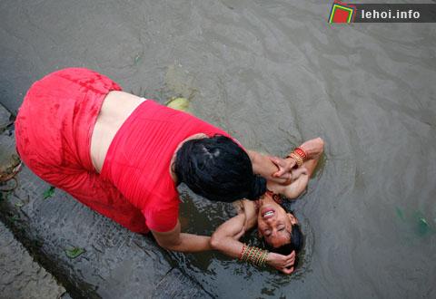 Một tín đồ Hindu đang trầm mình xuống nước sông Ganges tại Allahabad , Ấn Độ trong một lễ nghi Pind Daan.