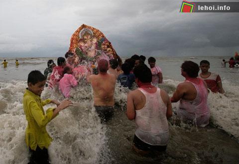Những tín đồ Hindu đang hất nước vào bức tượng trước khi đưa thần voi ra biển.