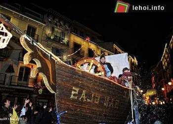 Trẻ em hóa trang thành chú hề, ngồi trên xe hoa và ném kẹo cho các bé đợi phía dưới