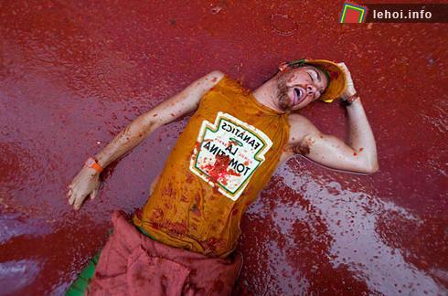 Trong khi có một anh chàng khác đang mặc chiếc áo in tên lễ hội Tomatina và thản nhiên nằm ngủ giữa biển nước cà chua. Tomatina là một lễ hội ném cà chua lớn nhất trên thế giới. Ảnh: AFP