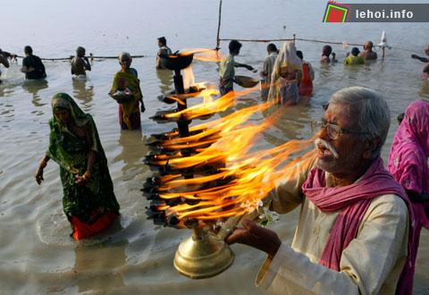 Một tín đồ Hindu đang cầu nguyện trên sông Ganges với cây đèn truyền thống tại Allahabad , Ấn Độ.