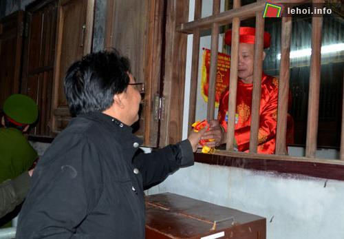 Các vị bô lão trong trang phục áo dài khăn xếp phát lương cho người dân