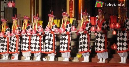 Các thầy sắp hàng ngang trước khi múa với hoa đăng lung linh trên tay