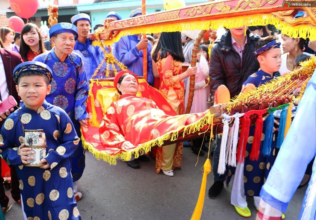 Một cụ bà được người nhà dùng võng rước lên miếu